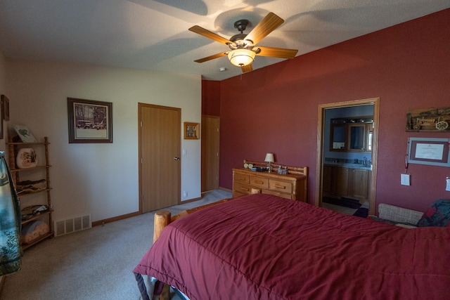 bedroom featuring ceiling fan, connected bathroom, carpet floors, and visible vents