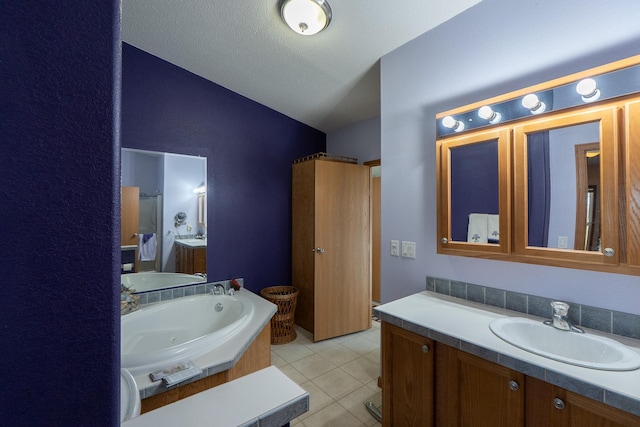 full bathroom featuring a sink, tile patterned flooring, a jetted tub, and two vanities