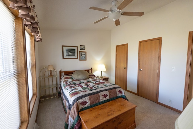 bedroom featuring ceiling fan, carpet floors, baseboards, and multiple closets