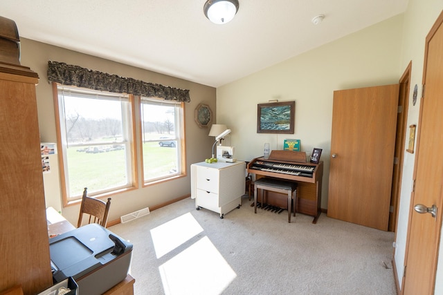 carpeted office featuring lofted ceiling and visible vents