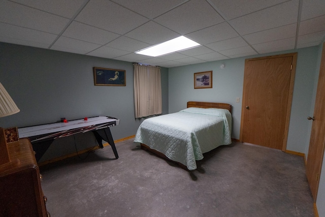 bedroom with a drop ceiling and baseboards