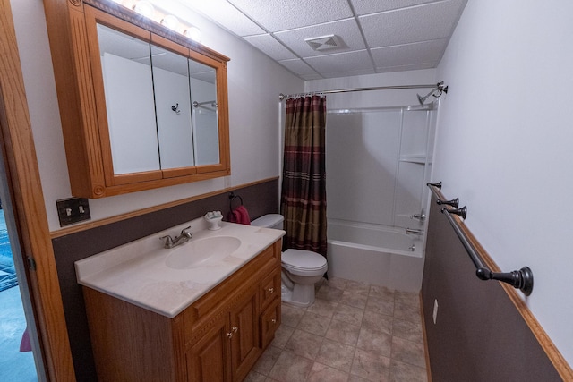 full bathroom featuring toilet, vanity, visible vents, shower / bath combo, and a drop ceiling