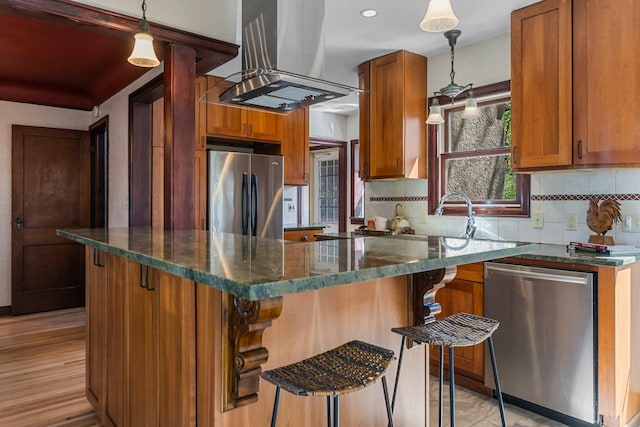 kitchen with stainless steel appliances, island exhaust hood, backsplash, brown cabinetry, and recessed lighting