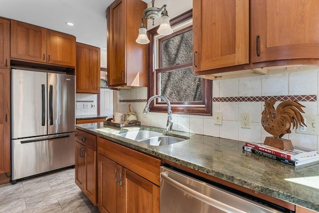 kitchen with stainless steel appliances, a sink, brown cabinets, backsplash, and recessed lighting