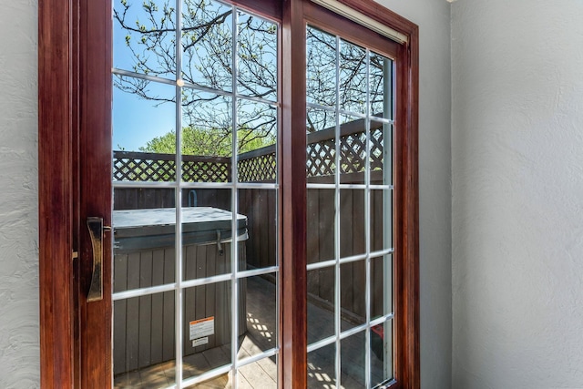 property entrance featuring an indoor hot tub and stucco siding