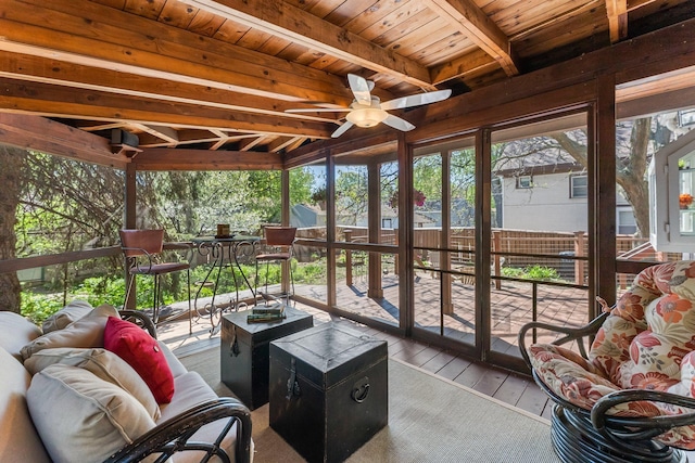 sunroom with a ceiling fan, beamed ceiling, and outdoor lounge area