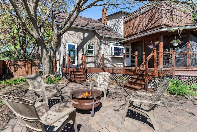 view of patio / terrace with a fire pit, a wooden deck, and fence