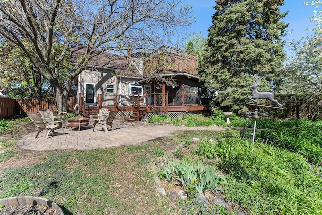 back of house with a patio area, a wooden deck, fence, and a fire pit