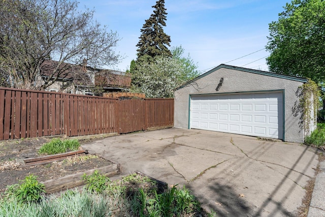 detached garage with a garden and fence