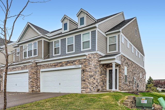 17935 Giants Way, Lakeville, MN 55044 - view of front facade featuring stone siding, an attached garage, a front yard, and asphalt driveway