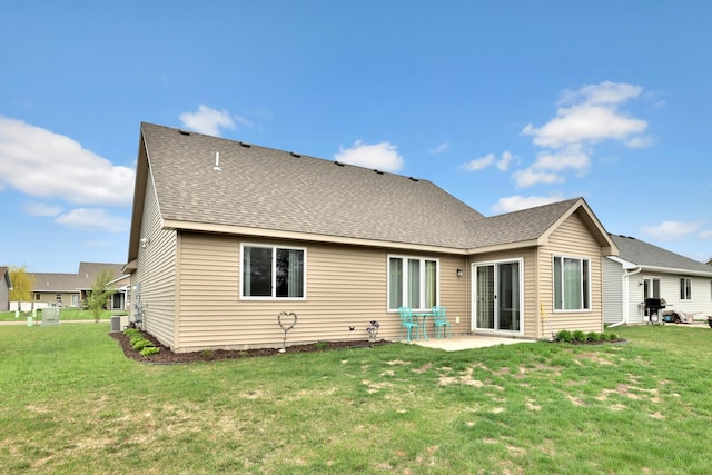 rear view of house featuring a lawn, a shingled roof, cooling unit, and a patio area