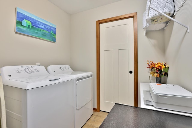 clothes washing area featuring laundry area, light wood-type flooring, and washer and dryer