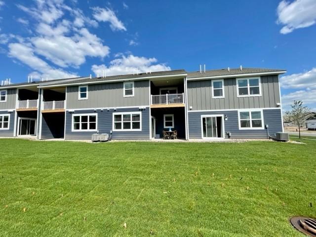 17121 Dysart Pl, Lakeville, MN 55044 - rear view of property featuring a balcony, a lawn, central AC, and board and batten siding
