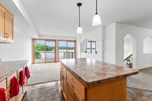 6300 Linden Ln, Mound, MN 55364 - kitchen with open floor plan, dark stone finish flooring, a kitchen island, and a water view