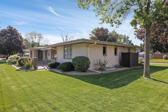 back of house with a yard and brick siding