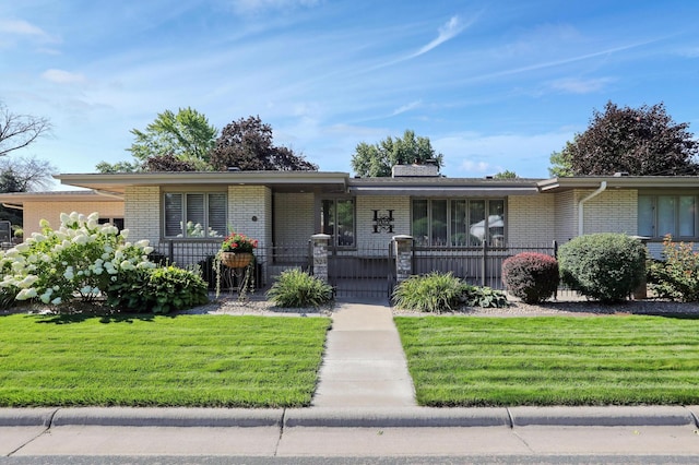 view of front of home featuring a fenced front yard, a front yard, and brick siding
