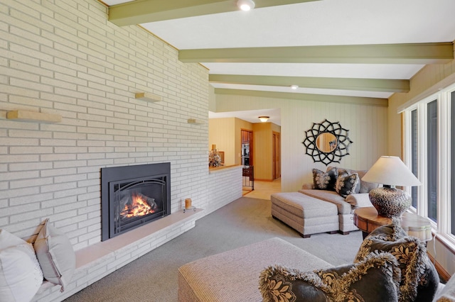 living area featuring carpet floors, a brick fireplace, and beamed ceiling