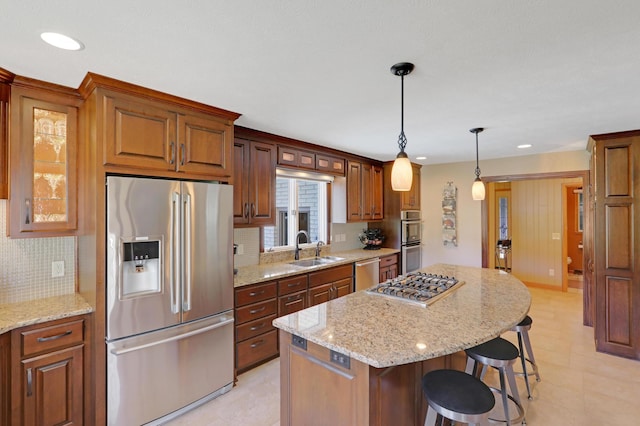 kitchen with a kitchen island, a breakfast bar, tasteful backsplash, a sink, and appliances with stainless steel finishes