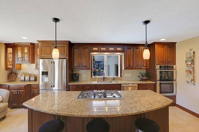 kitchen with a kitchen island, stainless steel appliances, a breakfast bar, and a sink