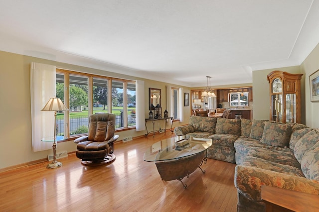 living area with visible vents and wood finished floors
