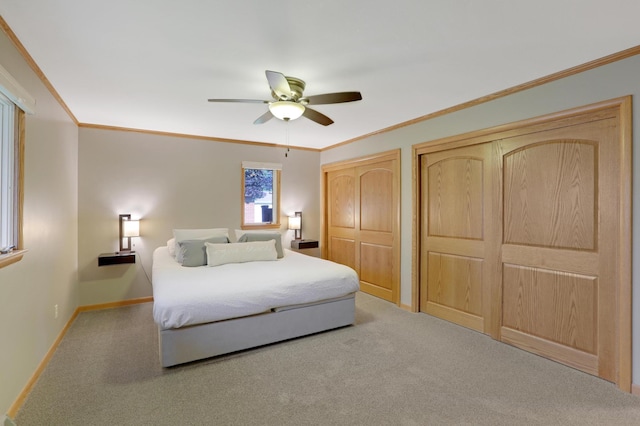 bedroom featuring crown molding, carpet floors, baseboards, and two closets