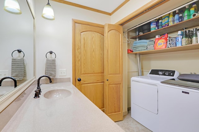 clothes washing area featuring laundry area, crown molding, a sink, light tile patterned flooring, and washer and clothes dryer