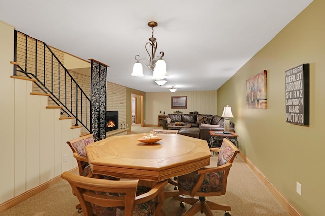 dining room with carpet floors, baseboards, stairs, and a fireplace