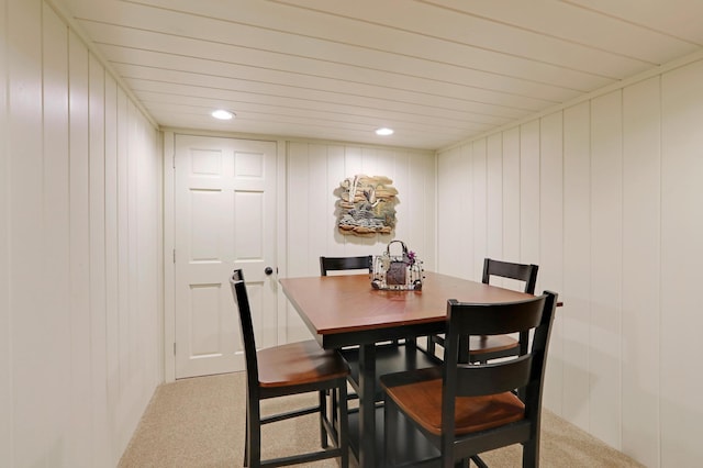 dining space with a decorative wall, carpet flooring, and recessed lighting