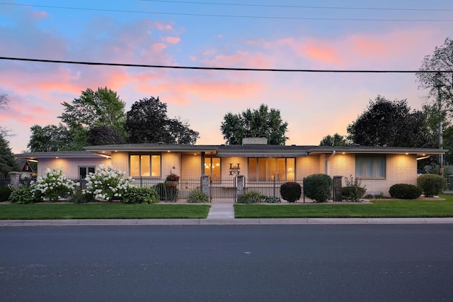 view of front of house featuring brick siding, a fenced front yard, and a chimney