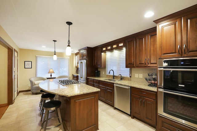 kitchen featuring decorative backsplash, a kitchen bar, light stone counters, a sink, and stainless steel appliances
