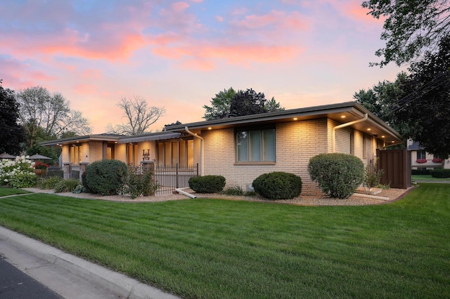 ranch-style house featuring brick siding and a front lawn