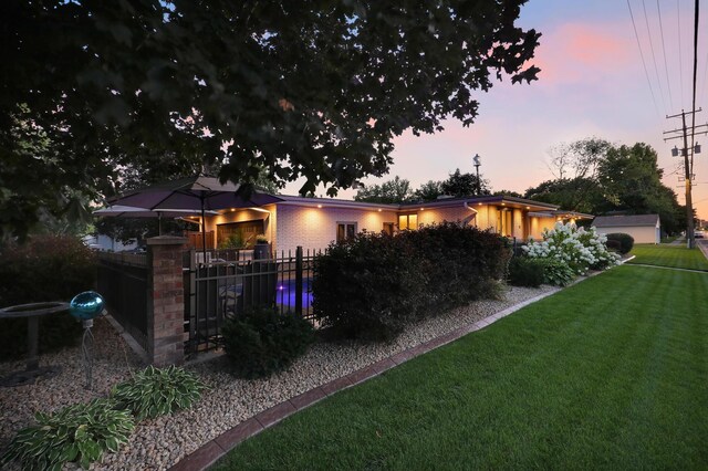 exterior space with fence, a yard, and brick siding