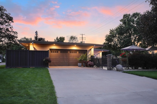 view of front of home featuring fence, a front yard, brick siding, concrete driveway, and an attached garage