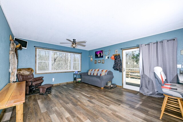 interior space featuring a ceiling fan, baseboards, and wood finished floors
