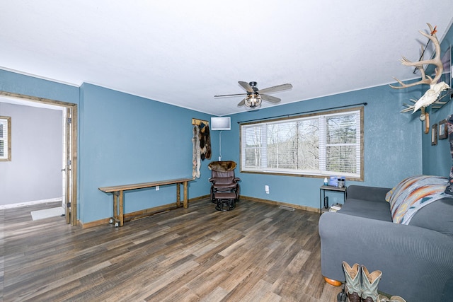 living area with ceiling fan, baseboards, and wood finished floors