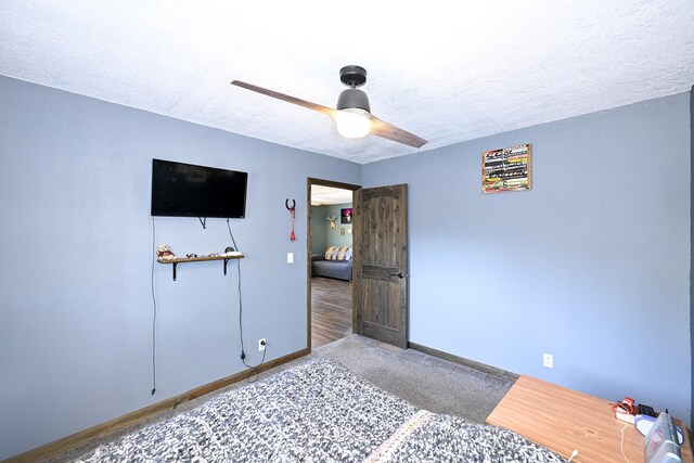 carpeted bedroom with baseboards, a ceiling fan, and a textured ceiling