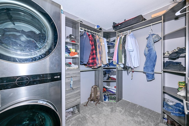 clothes washing area featuring carpet flooring, laundry area, and stacked washer and dryer