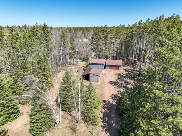 birds eye view of property featuring a forest view