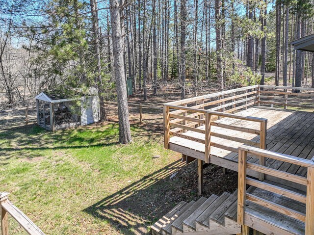 wooden deck featuring a yard, fence, and an outbuilding