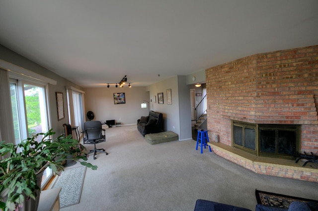 1224 Tee Up Ln, Red Wing, MN 55066 - carpeted living room with a fireplace, rail lighting, and stairway