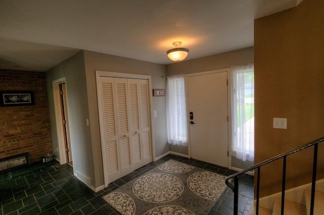 1224 Tee Up Ln, Red Wing, MN 55066 - foyer entrance featuring a brick fireplace, baseboards, and dark tile patterned flooring