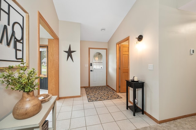 entrance foyer with baseboards, light tile patterned floors, and vaulted ceiling