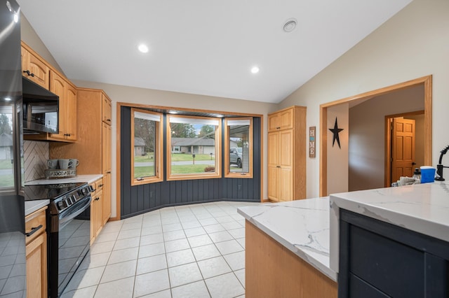 kitchen featuring light stone countertops, recessed lighting, light tile patterned floors, lofted ceiling, and black appliances