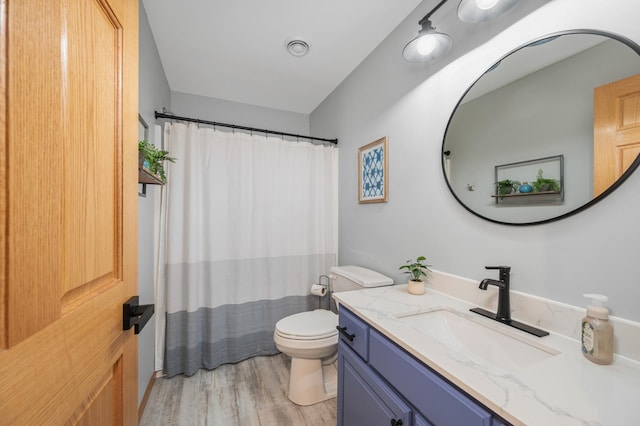 full bath with visible vents, curtained shower, wood finished floors, vanity, and toilet