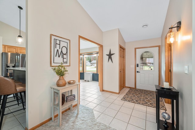 foyer with baseboards, light tile patterned flooring, a wealth of natural light, and high vaulted ceiling