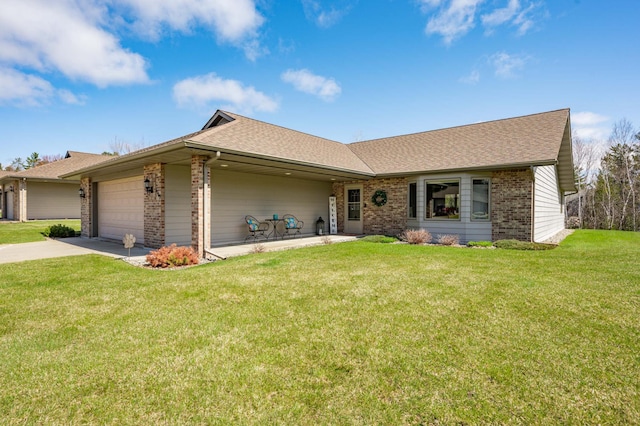 ranch-style home featuring a garage, brick siding, a front lawn, concrete driveway, and a shingled roof