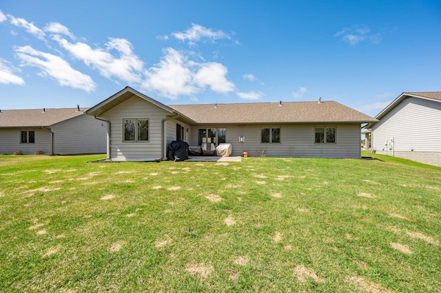 rear view of property featuring a lawn and a patio