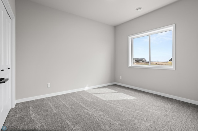 empty room with baseboards and carpet