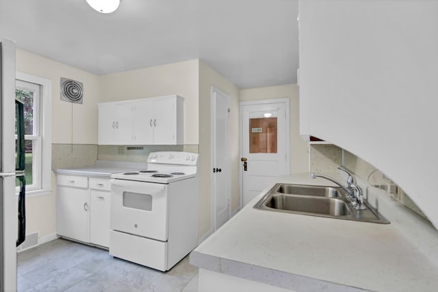 1217 High St, Lake City, MN 55041 - kitchen with white electric stove, a sink, decorative backsplash, white cabinets, and light countertops