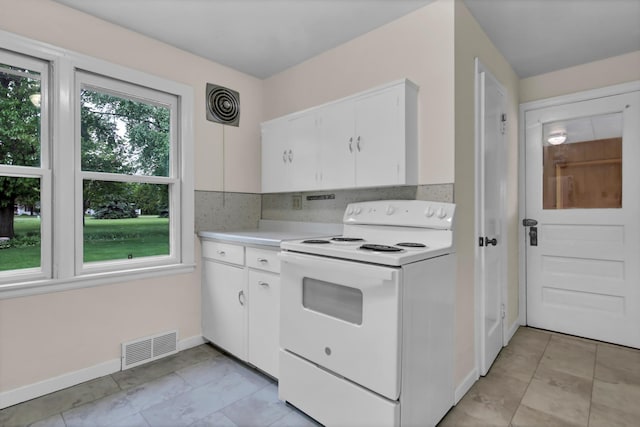 1217 High St, Lake City, MN 55041 - kitchen with white electric stove, plenty of natural light, light countertops, and white cabinets